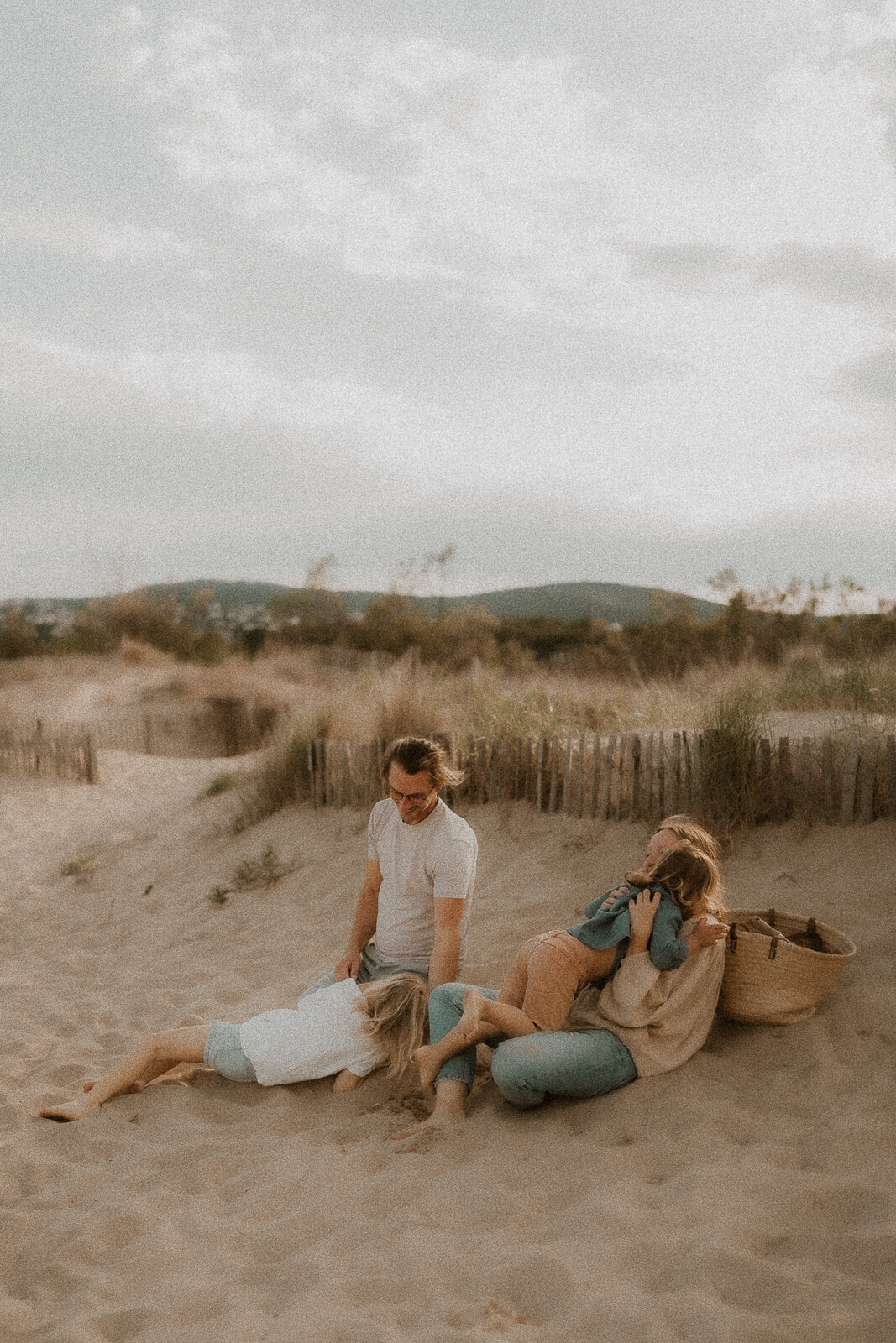 une famille rie et joue sur la plage