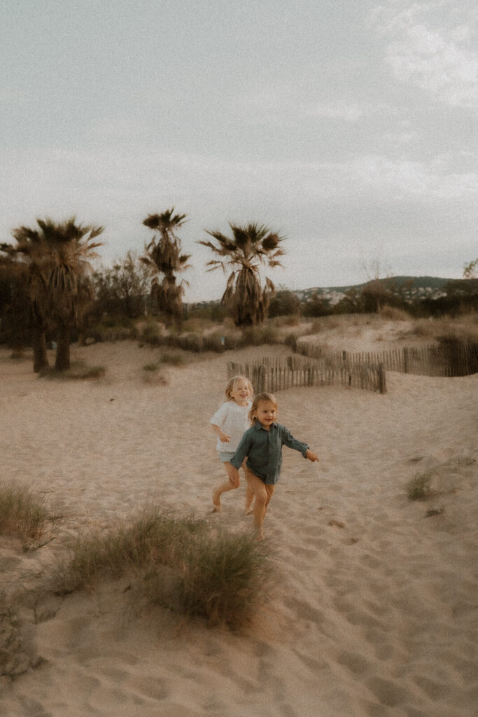 les enfants courent dans le sable sur la plage de saint aygulf lors de leur seance photo famille