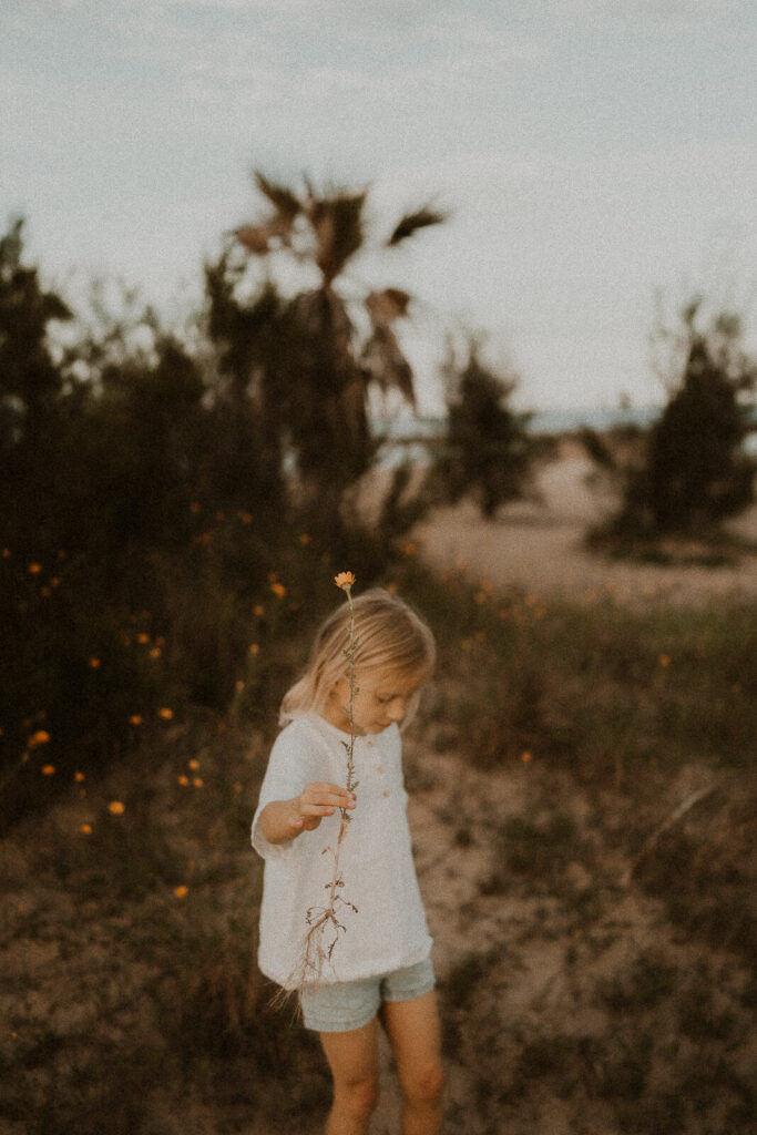 photo enfant qui cueille une fleur sur la plage de saint aygulf